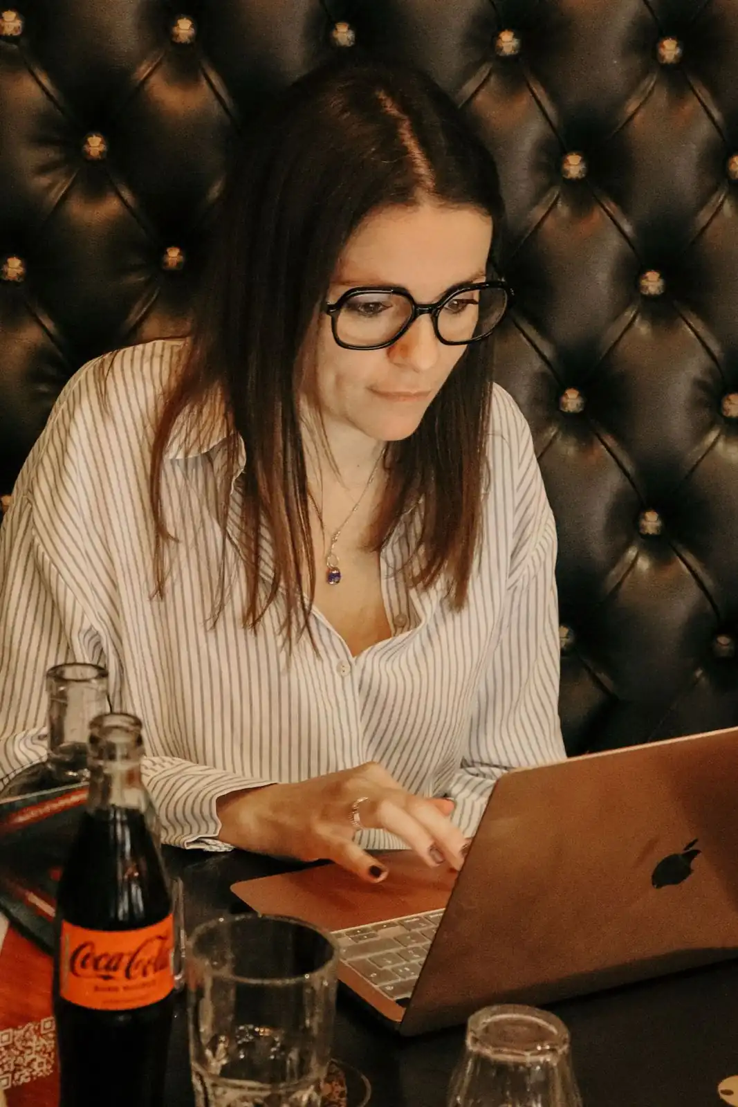 Julie Colombani travaillant sur son ordinateur portable, analyse des performances réseaux sociaux
